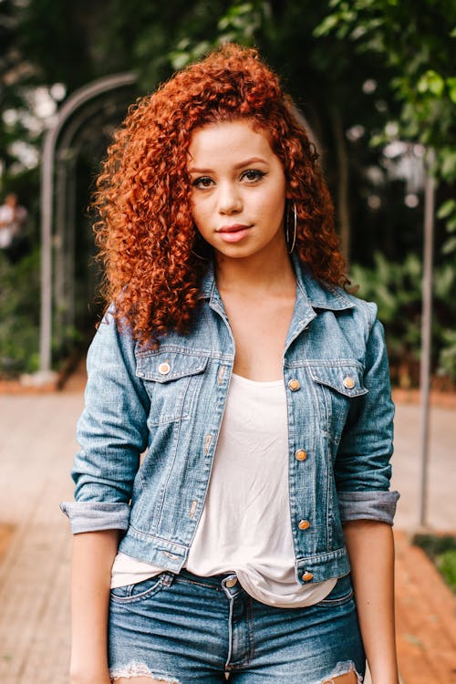 Free A woman with curly hair wearing denim Stock Photo