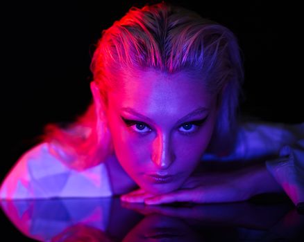 Modern studio portrait of a woman with intense lighting creating a dramatic mood.