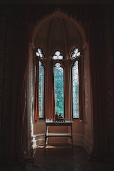 明亮的哥特式窗户配以复杂的玻璃，其下放置的复古桌子增添了一丝优雅