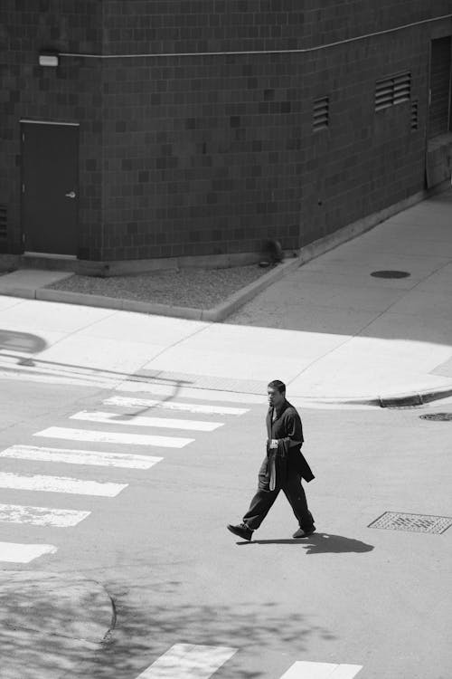 A man in a suit walking across a crosswalk