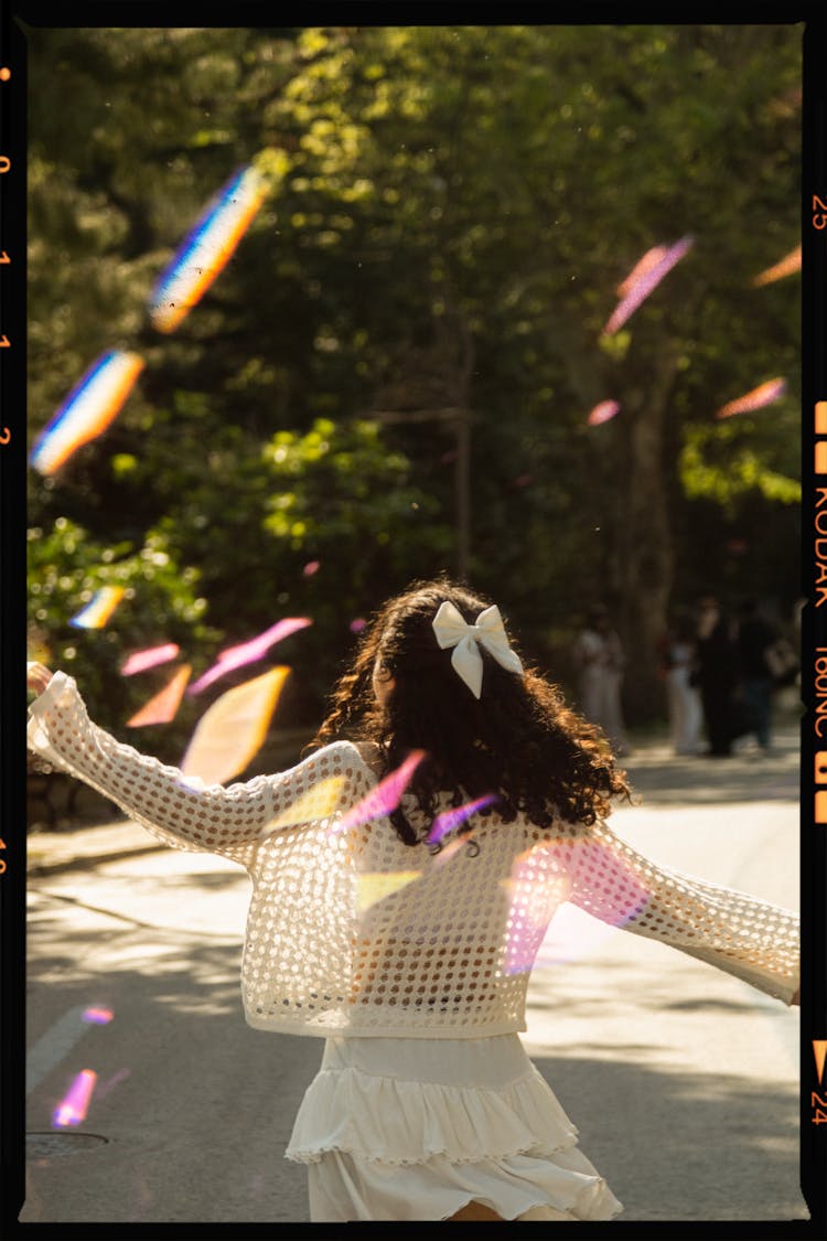 Back View Of A Girl With A Bow In Her Hair Walking In A Park 