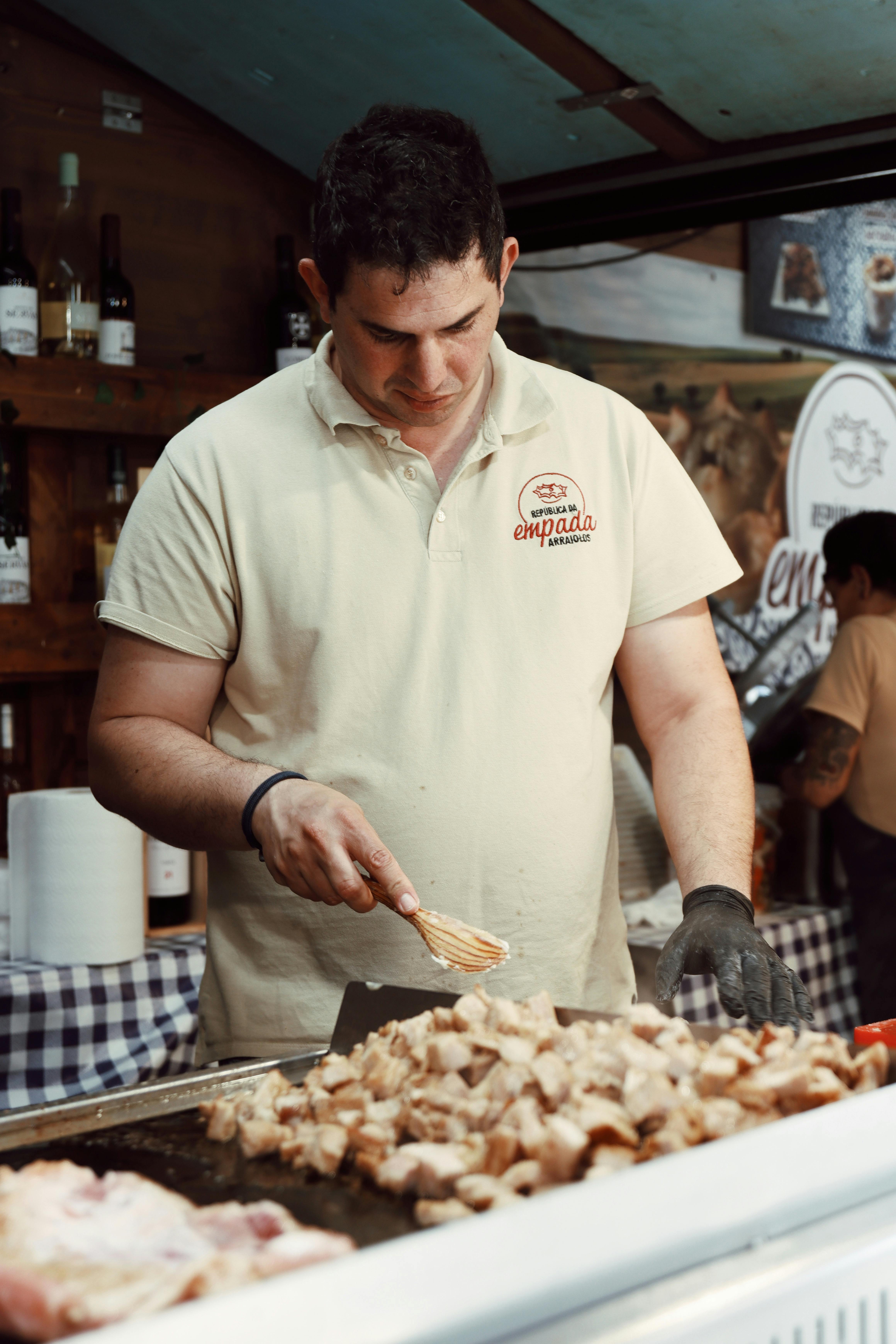 A chef preparing meat at a food truck in Lisbon, Portugal. Captures vibrant street food culture.