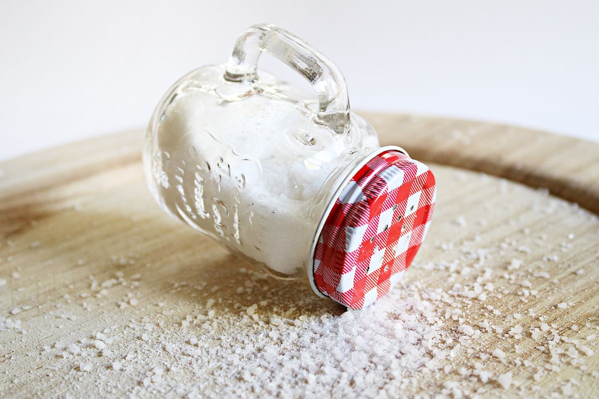 A jar of salt spilled across a wooden table - Salt of the Earth