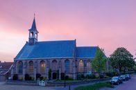 Beautiful Gothic church in Schipluiden, Netherlands, captured during a vibrant sunset.