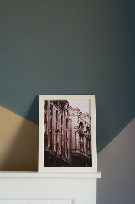 Framed photo of elegant architecture resting on a modern mantelpiece indoors.