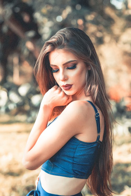 Free Side View Photo of Woman in Blue Crop Top Looking over Left Shoulder Stock Photo