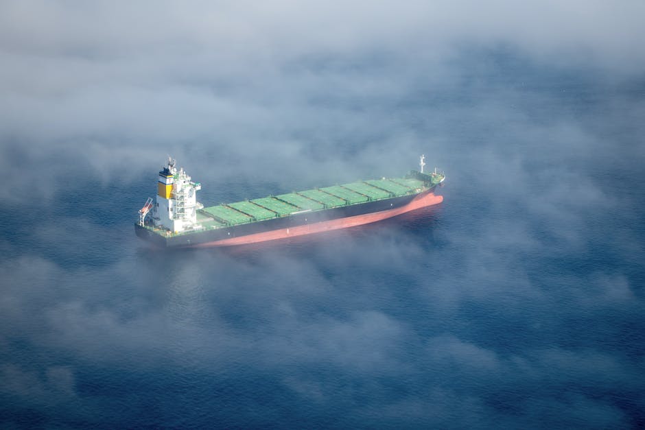Aerial shot of a container ship sailing through fog near Cape Town, South Africa.