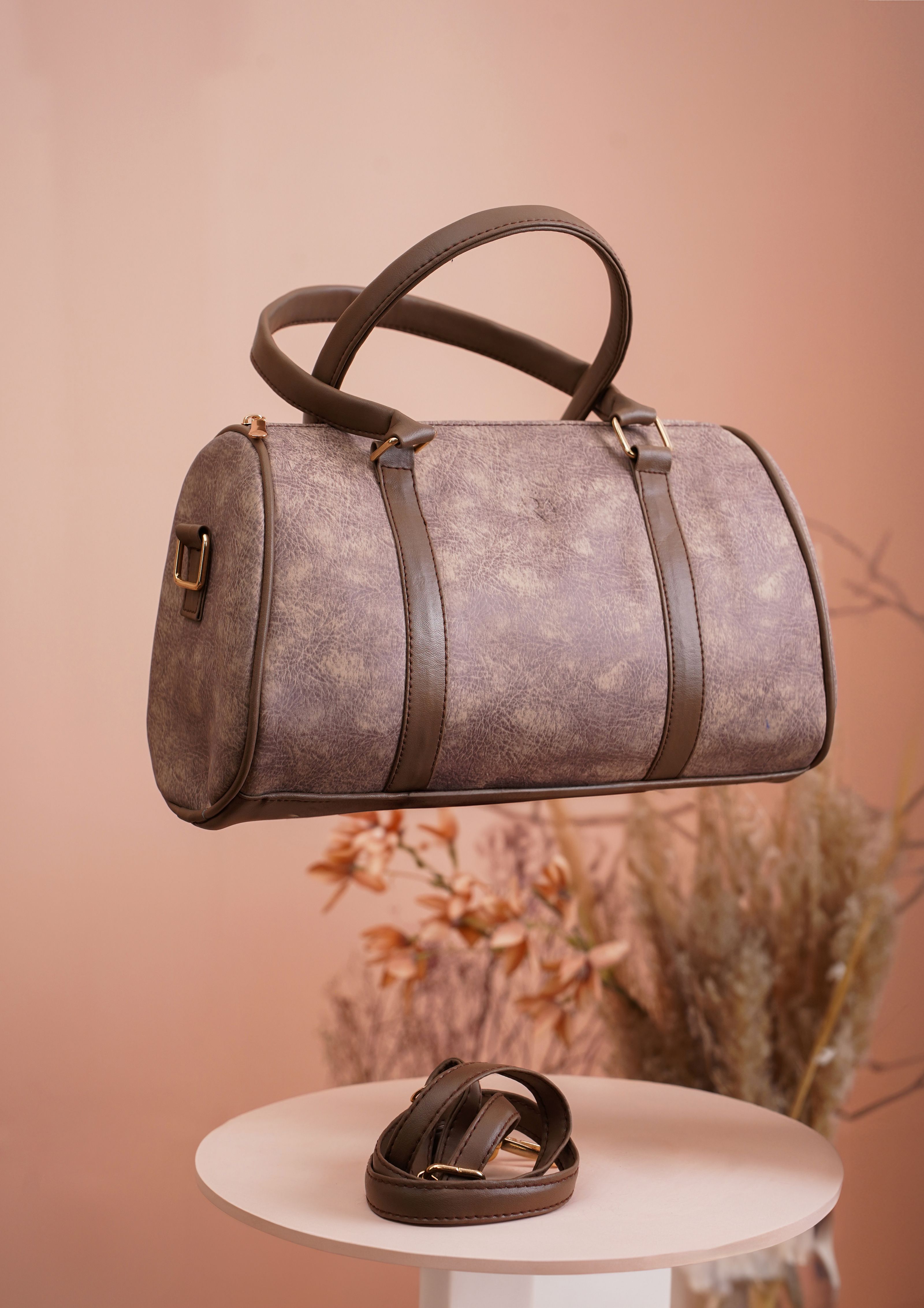 Bolsa de couro marrom estilosa com design minimalista em um ambiente de estúdio.