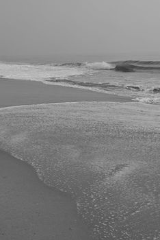 Serene black and white photo of waves on Chennai beach.