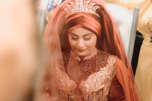 Free A beautiful bride in traditional red attire with intricate embroidery and tiara, looking down serenely. Stock Photo