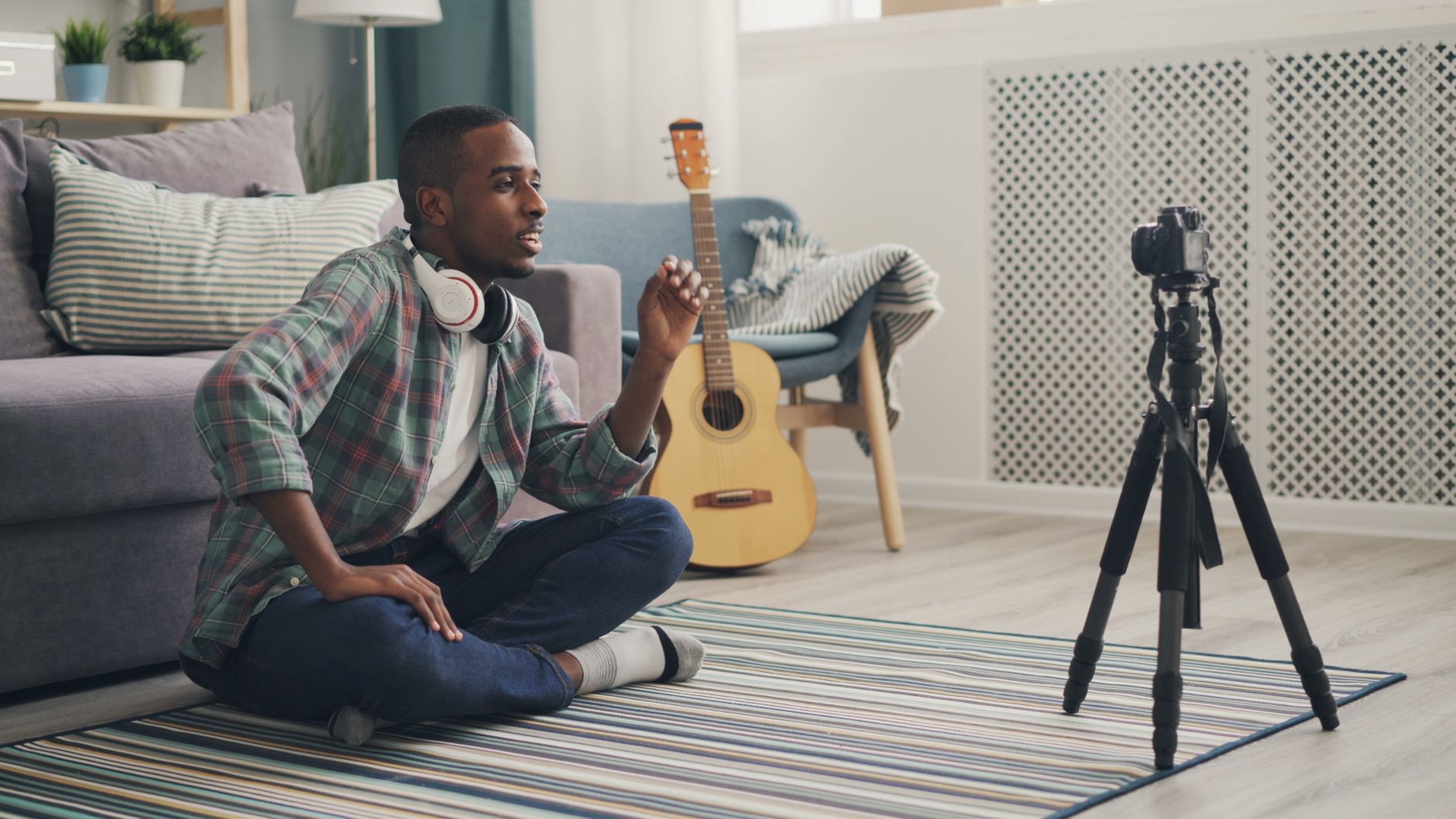 Young creator recording YouTube video with headphones and camera setup