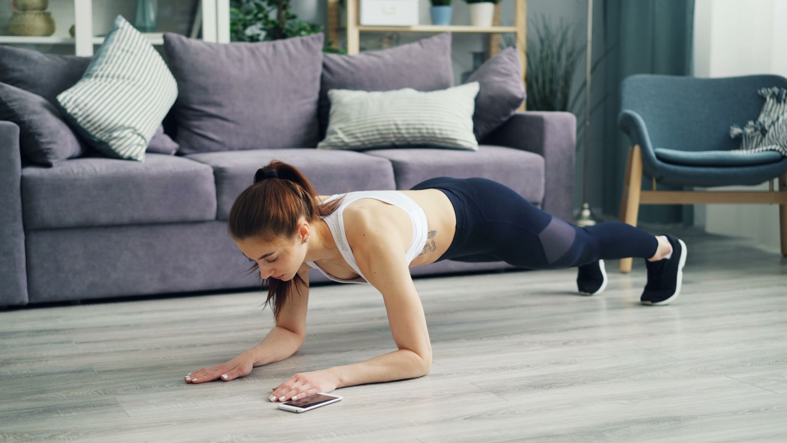 Beginner exercising in a clear living room space during an at-home workout