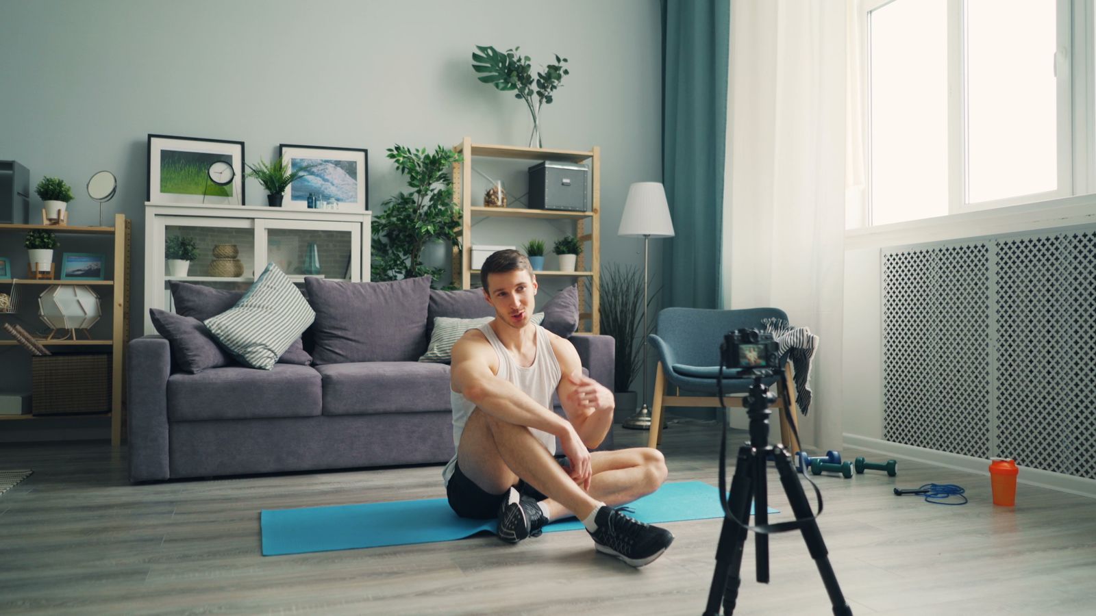 Person moving through a bodyweight workout in a cleared apartment space with no equipment