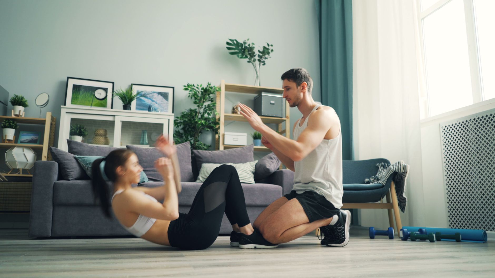 A couple exercising together at home with sit-ups and motivation.