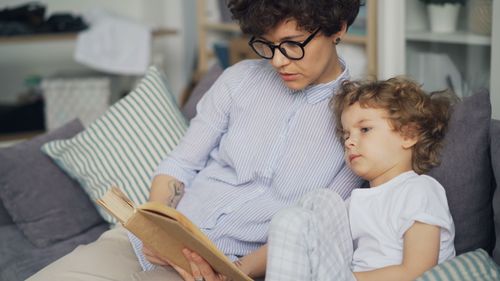 Free A mother and child reading a book together, sharing a cozy moment indoors. Stock Photo