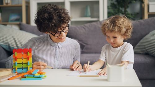 Free A mother and her child enjoying a drawing activity together, fostering creativity. Stock Photo