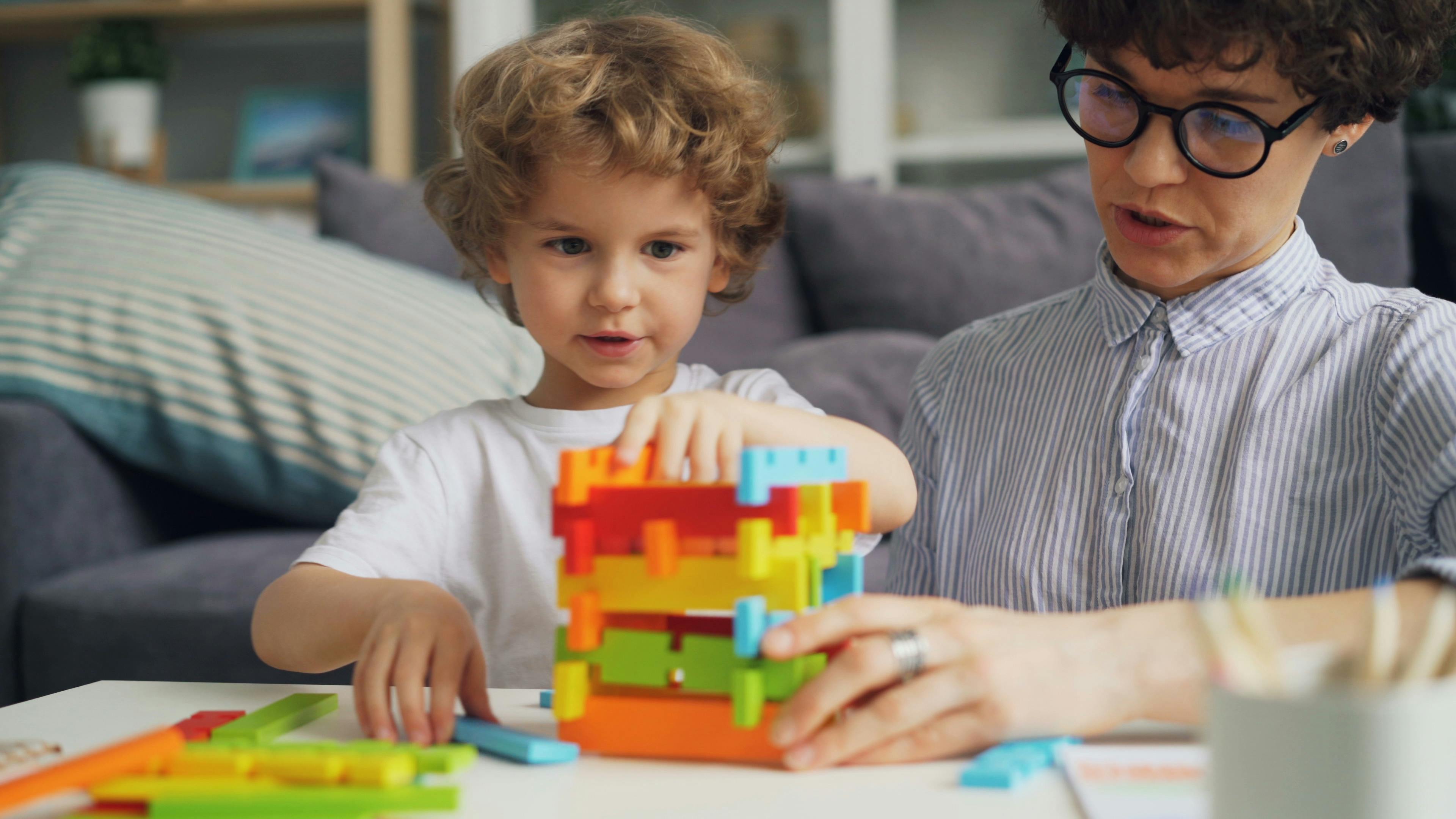 boy and mother playing with blocks on table