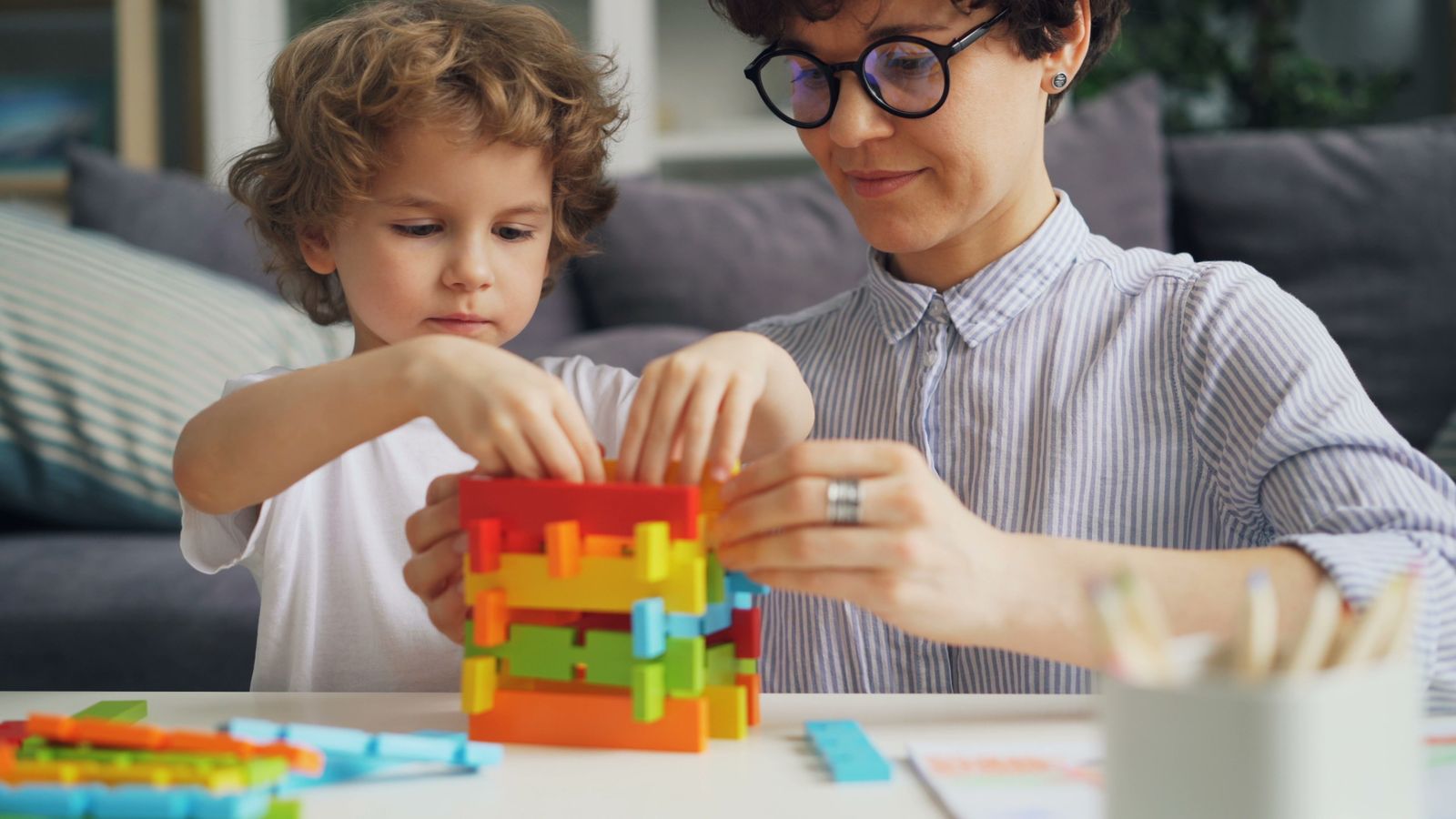 An adult and child sharing a building-block activity at home