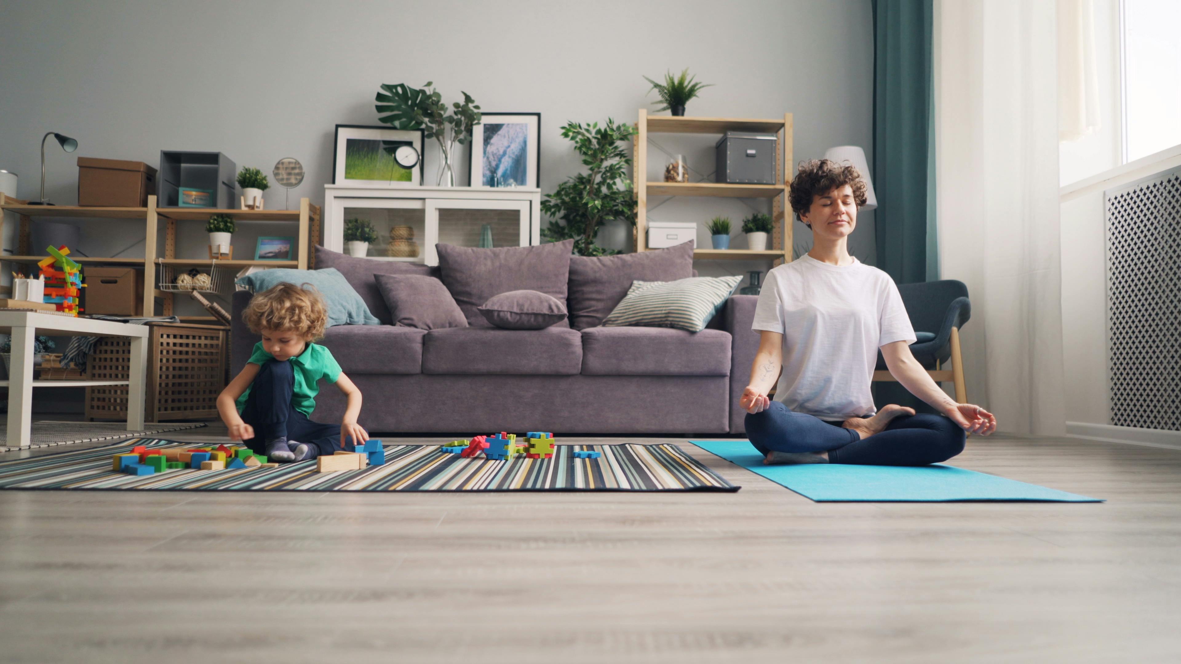 mother practicing yoga and boy playing near