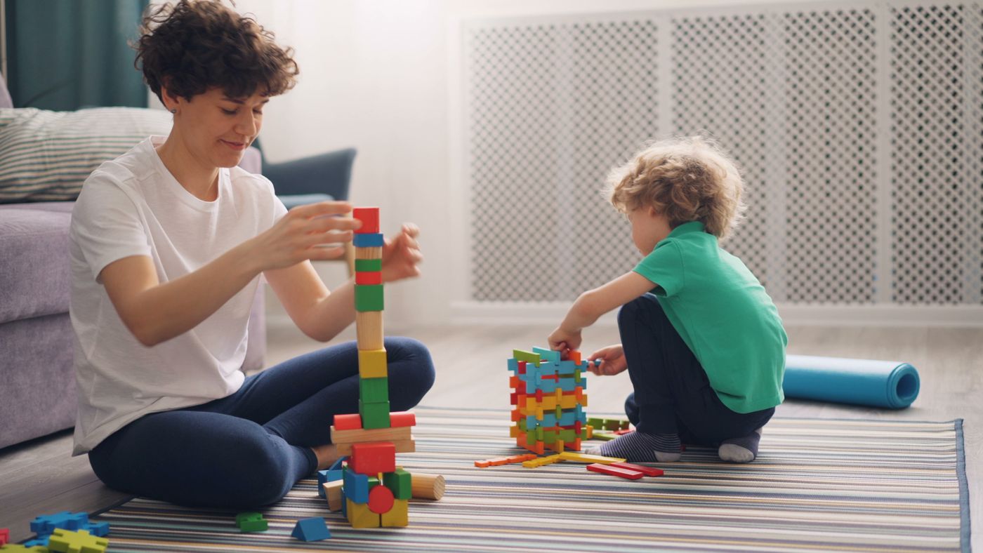 Parent and child playing together with colorful blocks