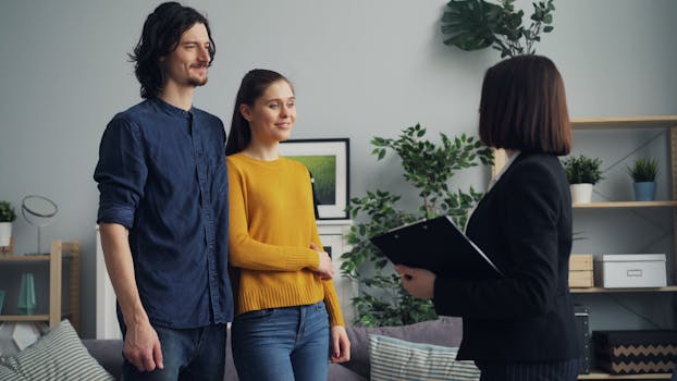 A couple engages with a real estate agent inside a modern living space.