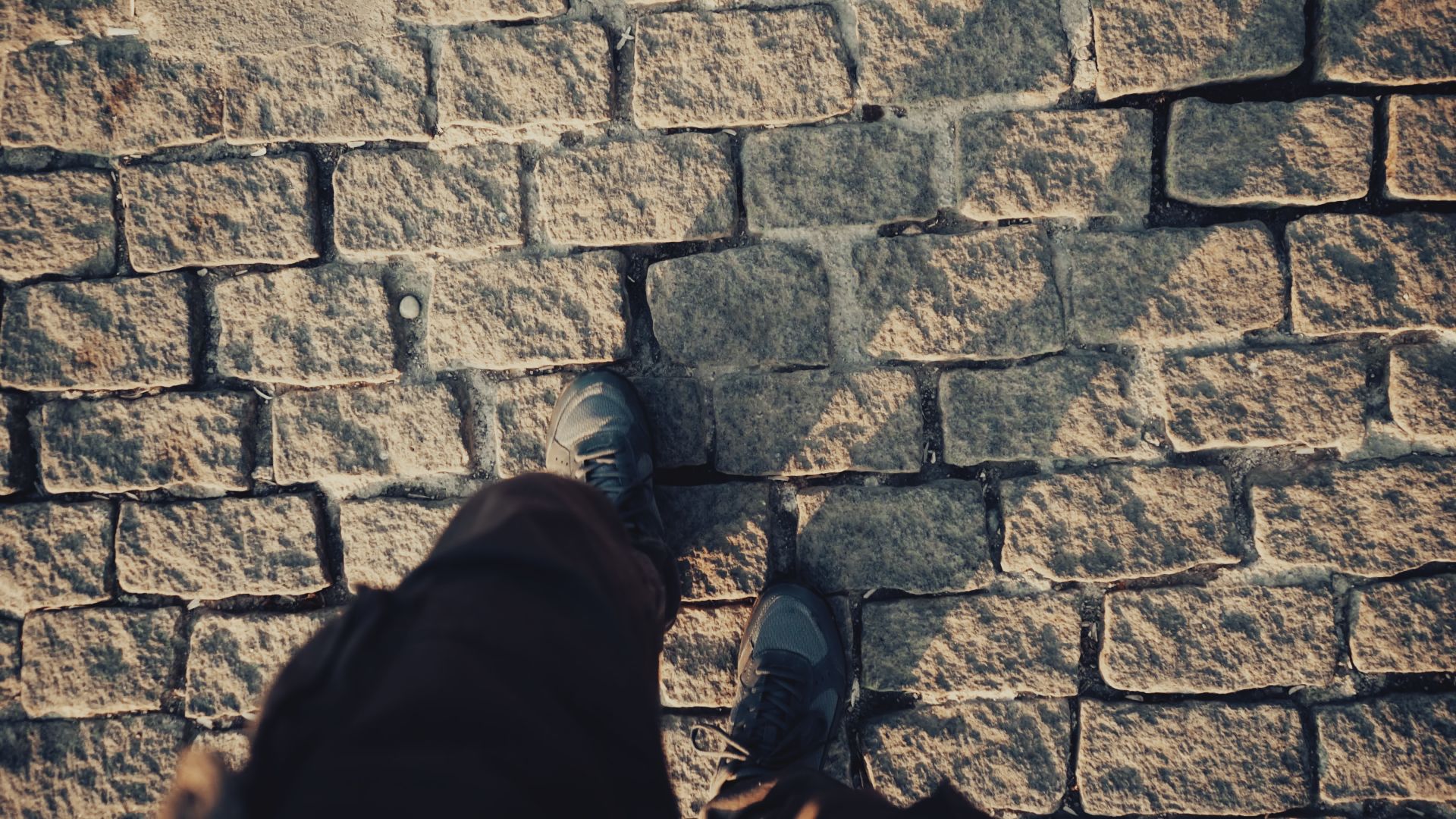 Legs and Shadows of Person on Cobblestone Pavement