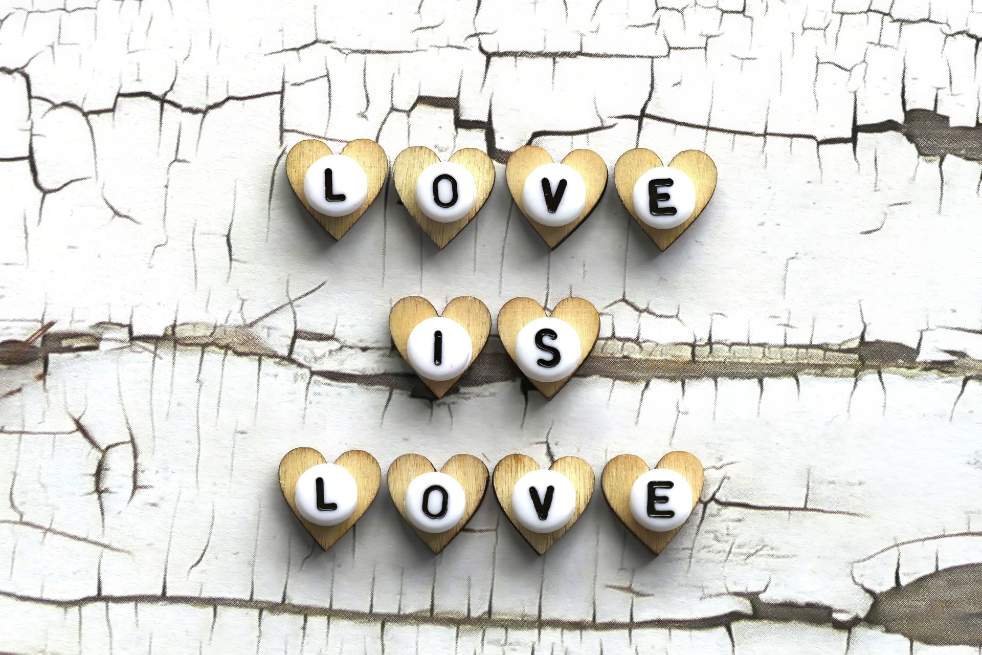 Heart-shaped love message on a textured white cracked wooden background.