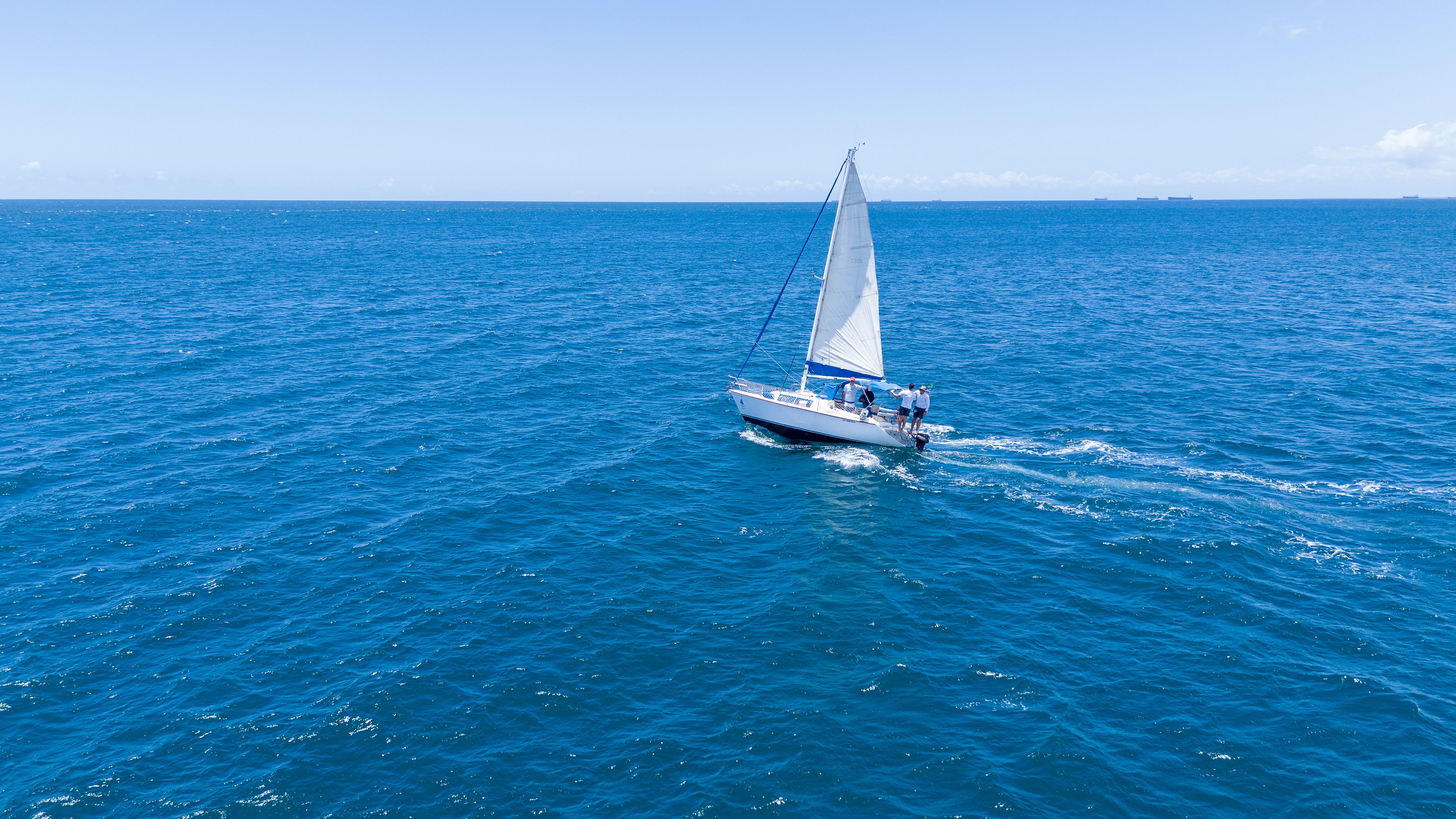 Unforgettable Small Group Yacht Sunset Cruise from Oahu Review: A Luxurious Evening on the Pacific Review 2026 - Aerial view of a sailboat gliding on the blue ocean near Salvador, Brazil.