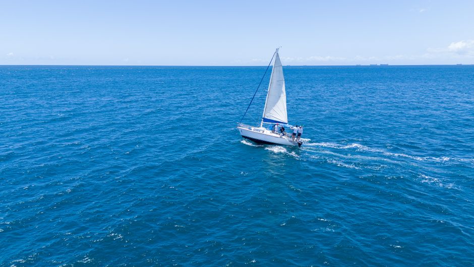 Unforgettable Small Group Yacht Sunset Cruise from Oahu Review: A Luxurious Evening on the Pacific Review 2026 - Aerial view of a sailboat gliding on the blue ocean near Salvador, Brazil.