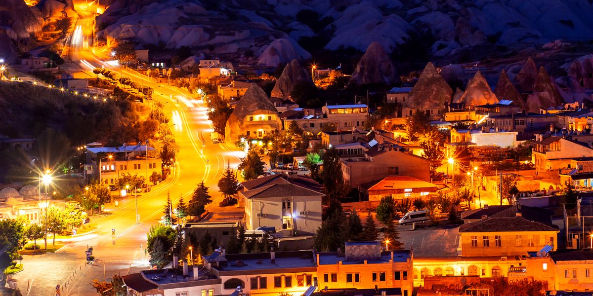 Panoramic view of Goreme village in Cappadocia with rock formations and cave hotels lit at dusk