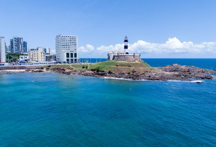 Aerial view of Barra Lighthouse and coastal skyline in sunny Salvador, Brazil.