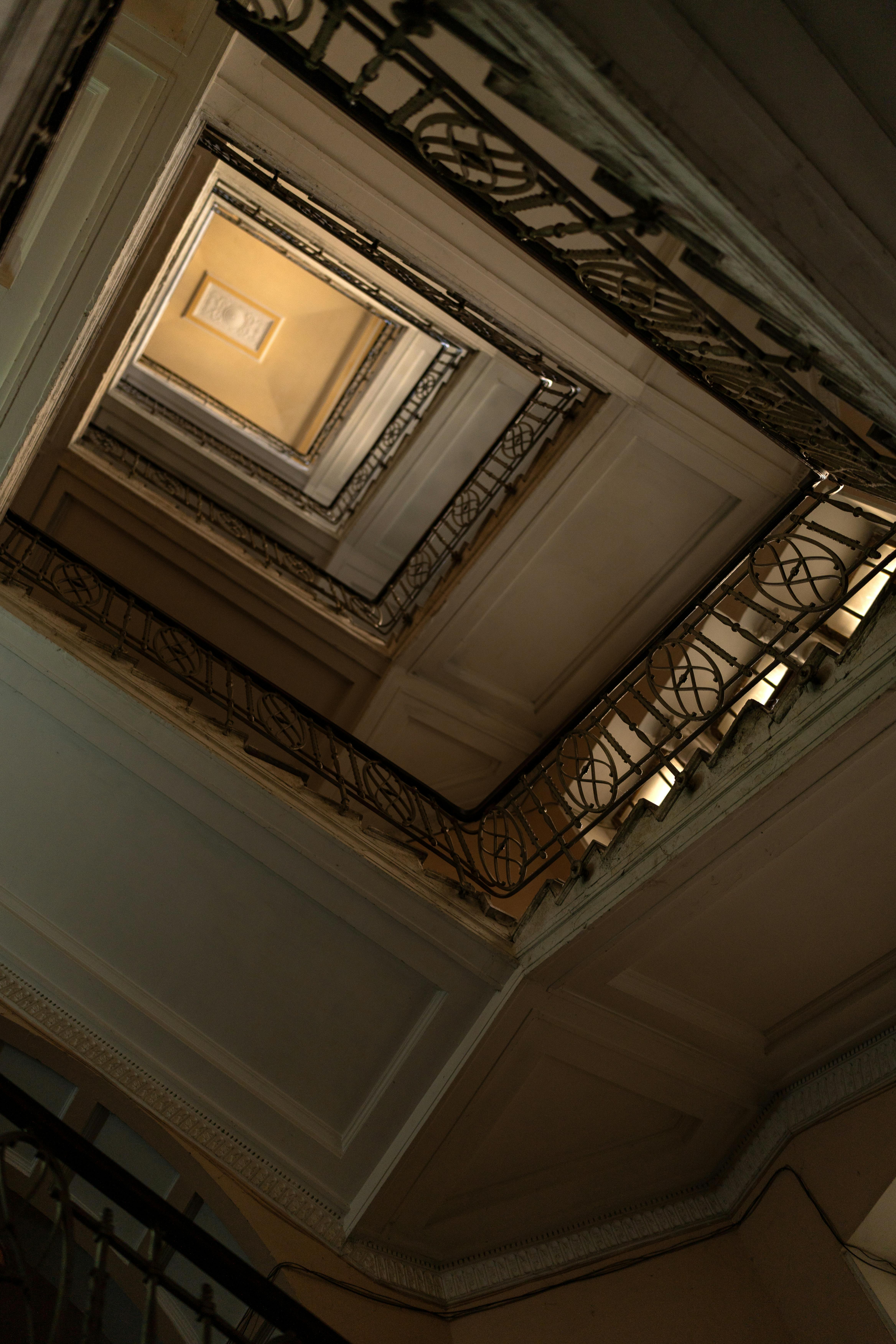 Captivating view of an interior staircase showcasing detailed iron railings in a unique low angle perspective.