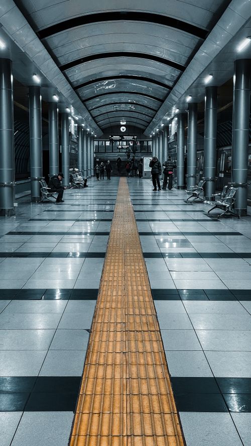 Free A sleek, modern subway station with few passengers seated and walking. Stock Photo