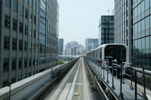 Monorail train moving through Tokyo's urban skyline with towering buildings.
