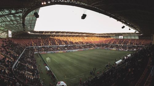 Free Wide-angle view of a lively soccer match in an Iraqi stadium, showcasing vibrant atmosphere and architectural details. Stock Photo