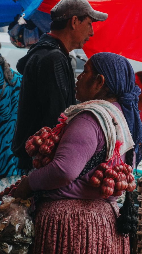 Free A woman vendor with garlic at a rural market, showcasing local produce. Stock Photo
