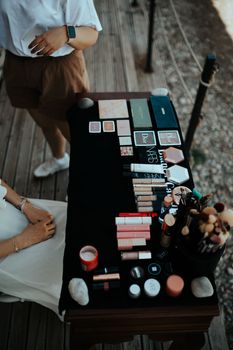 Top view of various makeup products on a table outdoors in Muğla, Türkiye.