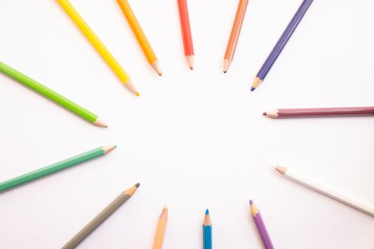 A vibrant circle of colored pencils on a white background, ideal for creativity themes.
