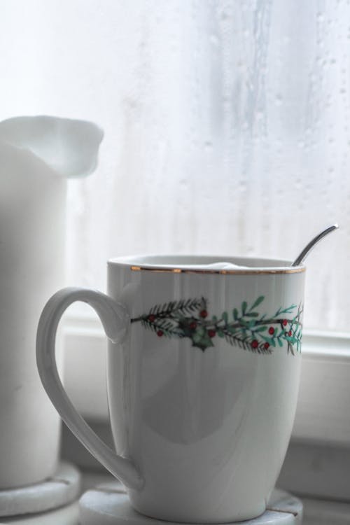 A cup of coffee sits on a window sill