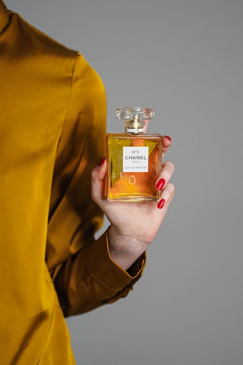 A woman holding a bottle of perfume