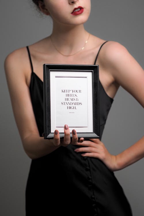 A woman holding up a picture frame with the words'you are beautiful'