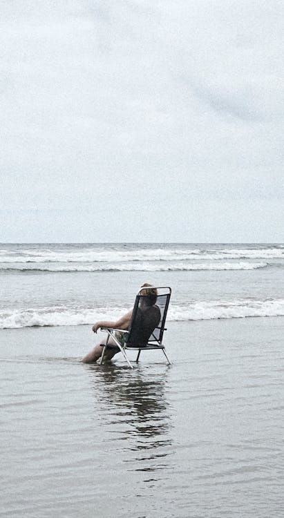 A man sitting in a chair in the ocean