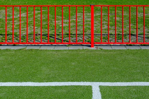 A red fence on a soccer field