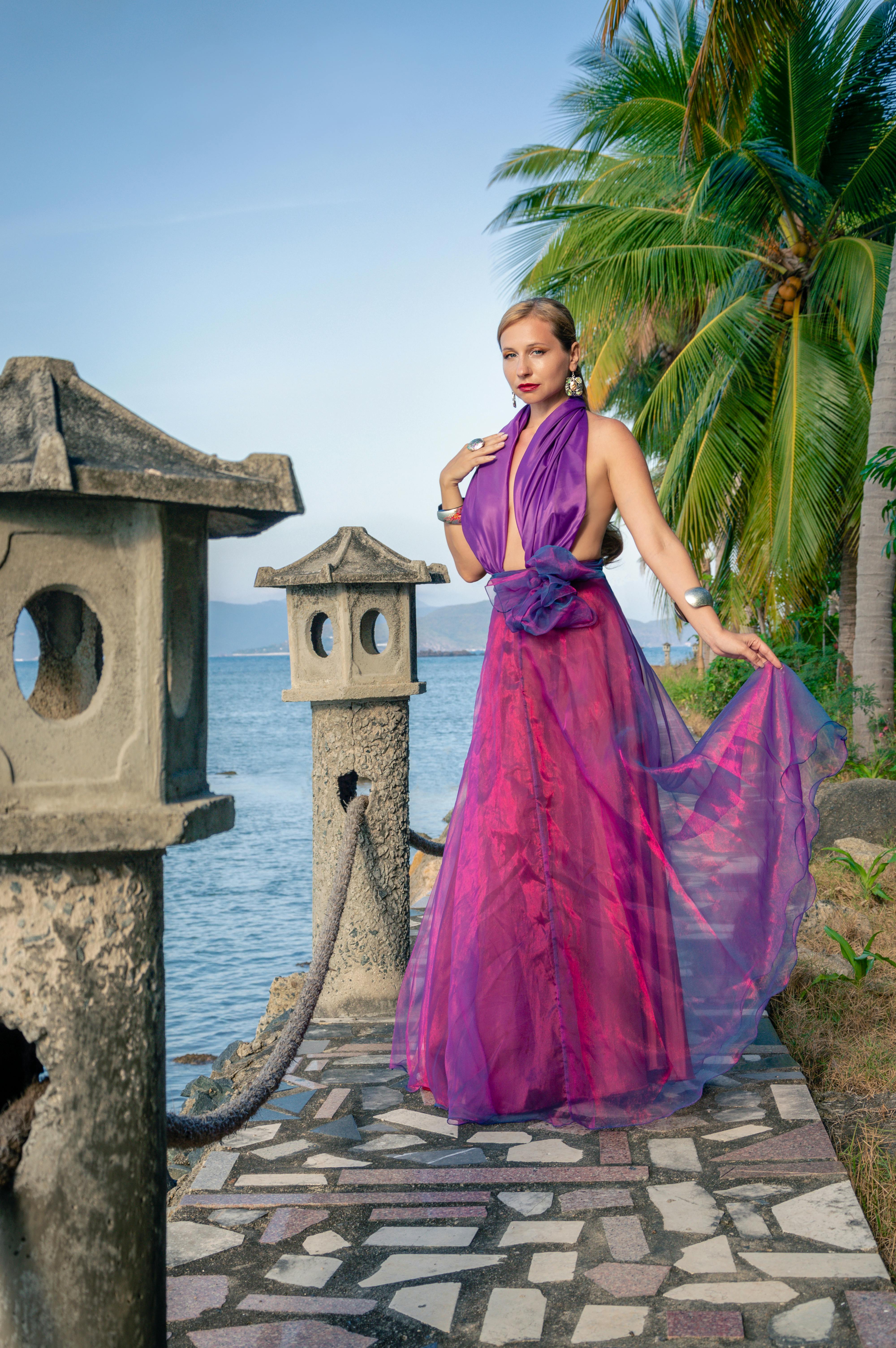 Free A woman in a purple dress standing on a pier Stock Photo