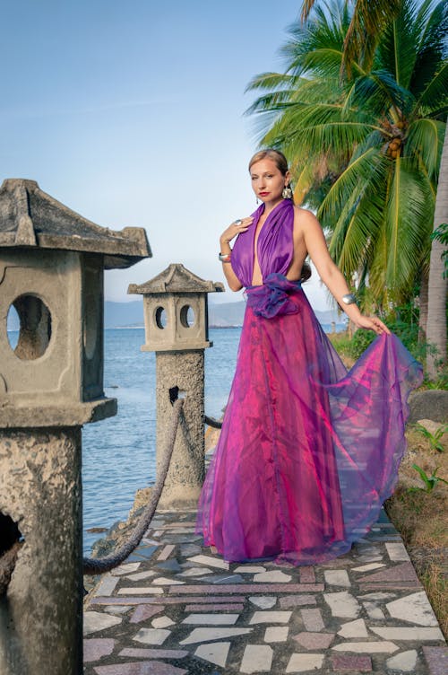 Free A woman in a purple dress standing on a pier Stock Photo