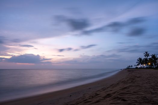 Peaceful beach scene at twilight with gentle waves and a serene sky, perfect for relaxation themes.