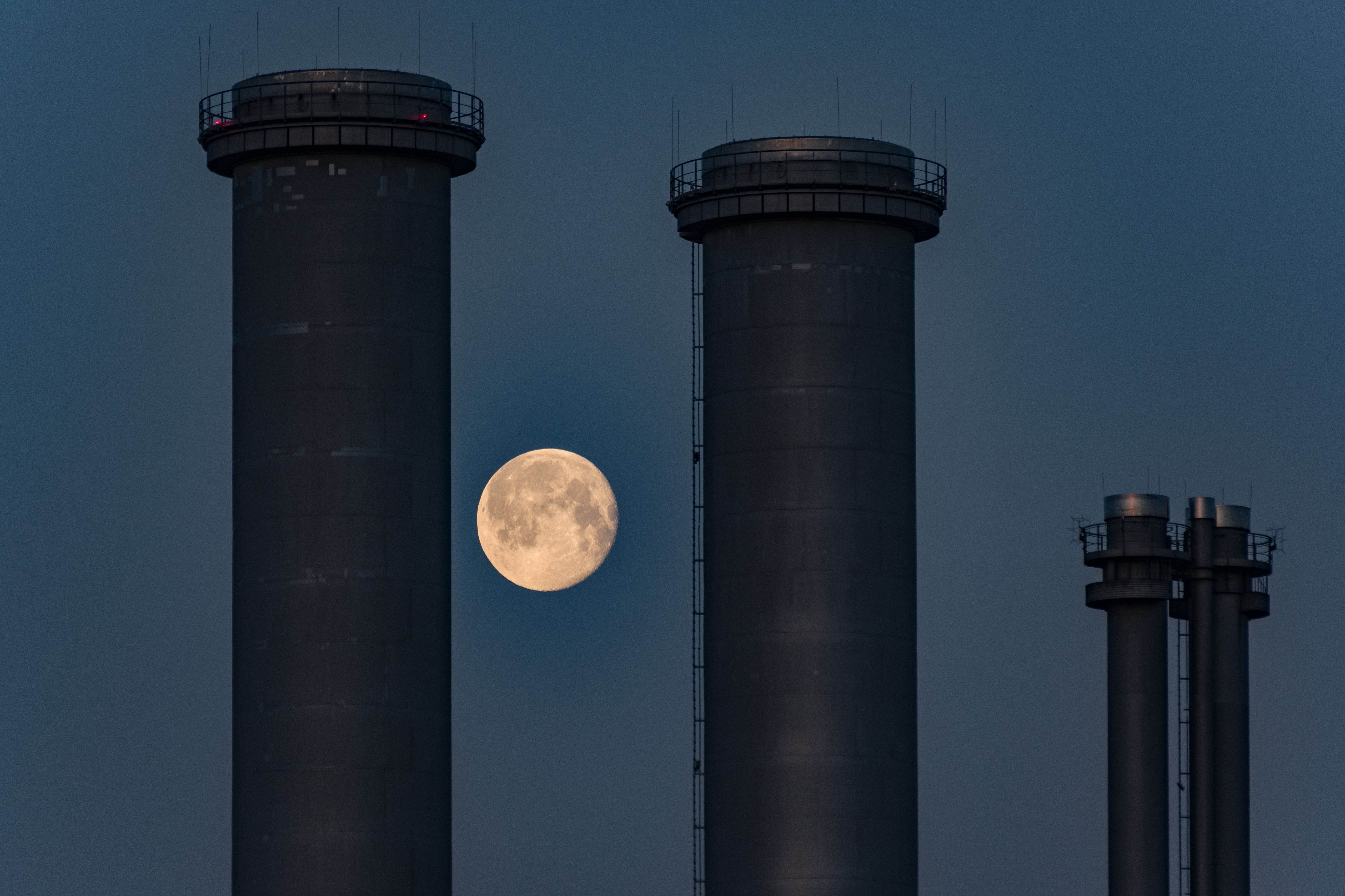 The moon rises over the chimneys of a power plant · Free Stock Photo