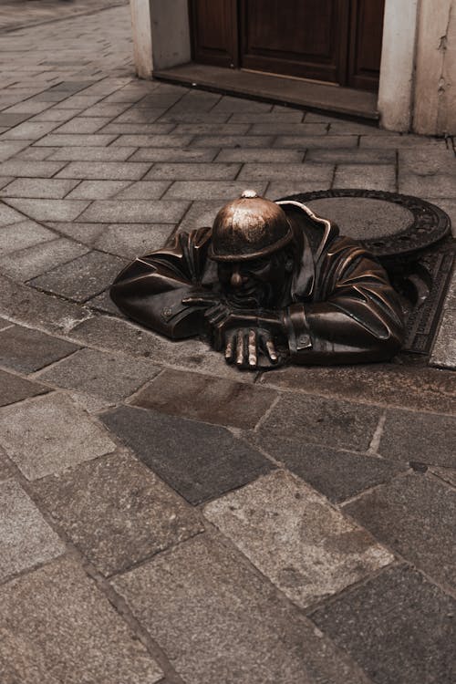 A statue of a man laying down in a hole