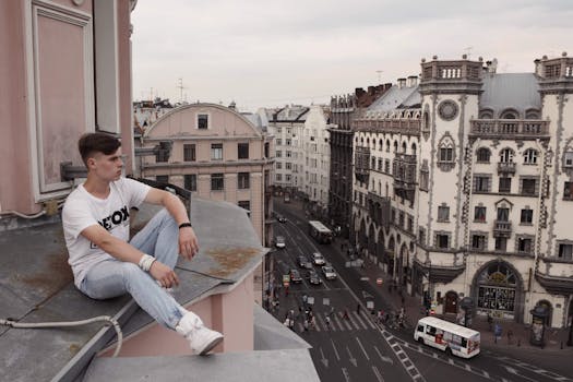 年轻人坐在屋顶上，俯瞰着城市中具有历史感的建筑街道
