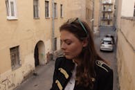 一位女子在老巷中闭着双眼的坦率肖像